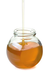 Jar with flowing honey on white