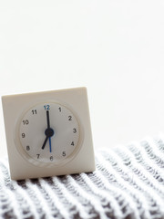 Series of a simple white analog clock on the blanket, 5/15