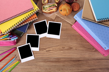 Several four polaroid style photo print frame on a college student or school desk with books and education accessories