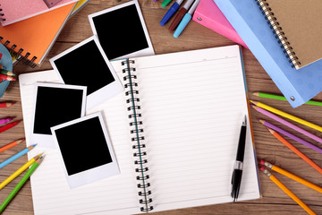 Several four polaroid style photo print frame on a college student or school desk with photo album notebook or scrapbook and education accessories