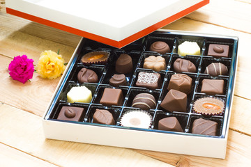 Chocolate candy in the box on wood background.