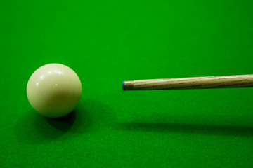Snooker cue with snooker ball on green table background