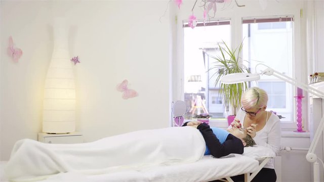 Eyelash salon with person working on customer 4K