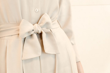 details of bow belt tie in beige woman dress outfit style.