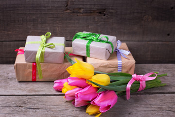 Bright yellow and pink spring tulips and wrapped  boxes with pre