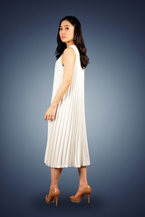Young Asian woman in white dress  on dark blue background