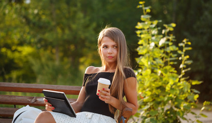 Girl drinking coffee and holding tablet pc