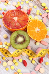 Natural fruits, centimeter and medical pills, slimming, choice between healthy nutrition and medical supplements