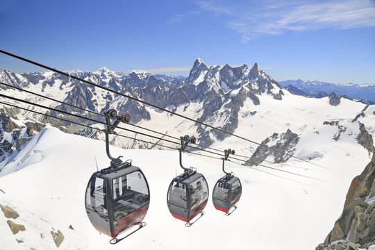 Tourists enjoying the majestic landscape in gondolas from Point Helbronner to Aiguille du Midi, France