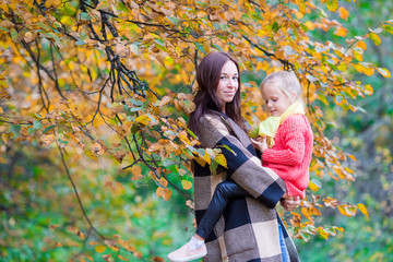 Naklejka premium Happy mom with little daughter on beautiful autumn day