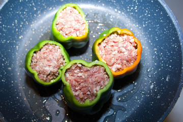 four stuffed with minced pepper in a frying pan, top view