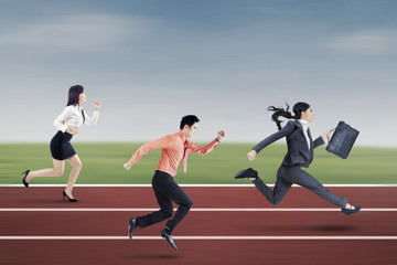 Fototapeta premium Three entrepreneurs running on the track