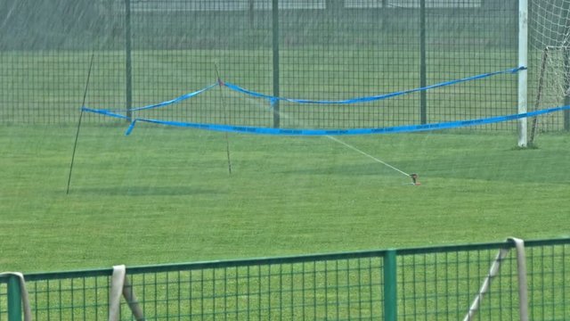 Spraying soccer playground on a rain day