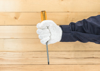 Hand in glove holding screwdriver