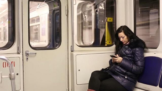 Woman In A Subway Car Uses A Smartphone