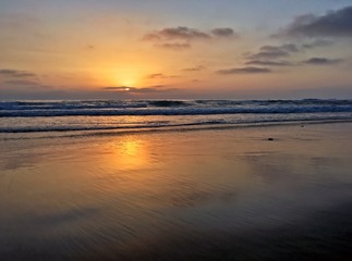 Beautiful sunset with reflections along empty beach
