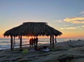 Silhouette of women under a beach shack in La Jolla, California. 