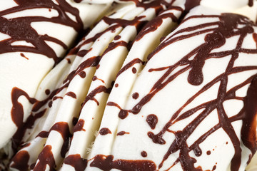 Pats of ice-cream with chocolate syrup.
