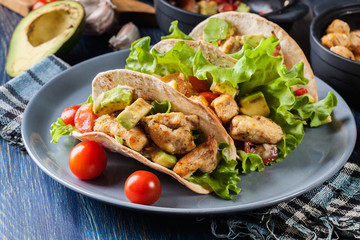 Authentic mexican tacos with chicken and salsa with avocado, tomatoes and chillies
