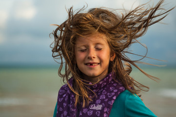 Girl with developing hair in the wind