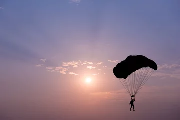 Fototapete Luftsport Silhouette of parachute on sunset background