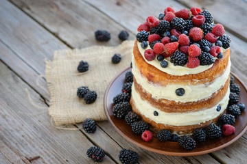 Tasty cake with strawberry, raspberry and blackberry on a wooden table