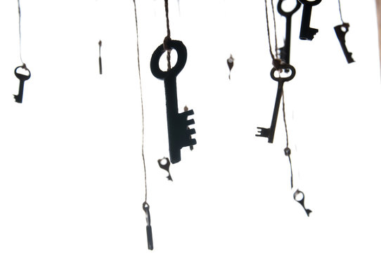 Many rustic keys hanging on string. Selective focus. Isolated