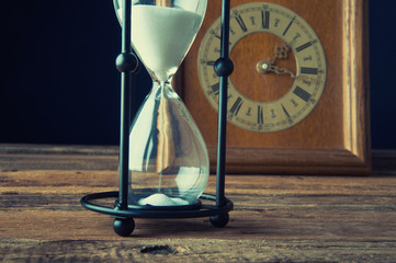 Hourglass and old vintage clock