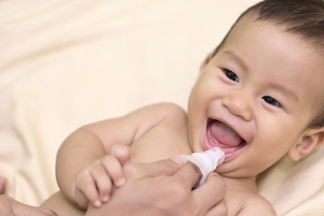 Mother cleans baby mouth