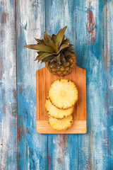 Pineapple on the blue vintage wooden plate with circular cut up