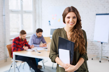 Cheerful female student standing in classroom