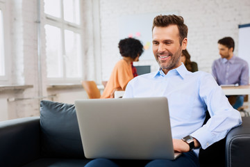 Businessman sitting on couch at office