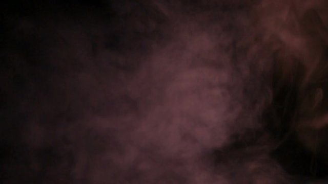 Fumo reale rosso prodotto da macchina del fumo con sfondo nero. Slow Motion. 