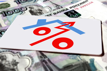 Red percent sign on a background of money . The concept of price changes on the real estate market