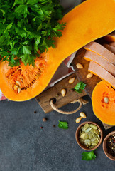 The cut pieces of pumpkin with parsley on a black background 