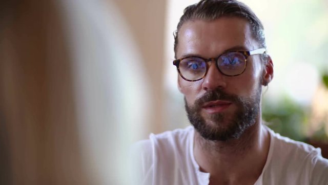 Hipster brunette man leave young blonde woman in cafe. His facial and eye expression were seriouse