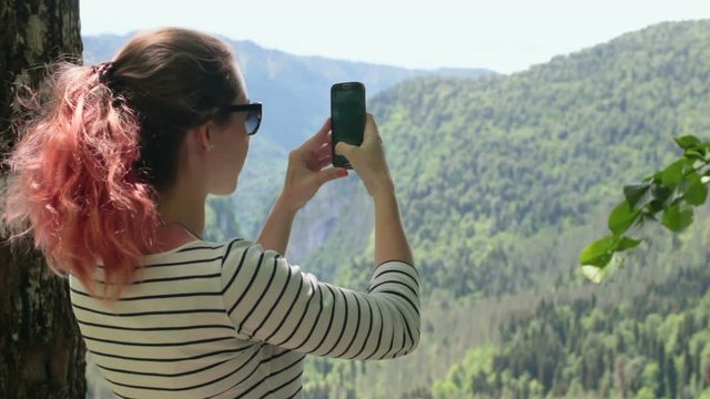 Girl taking photo the mountain with smart phone HD