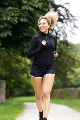 Beautiful female runner outside smiling