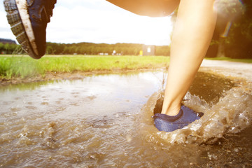 Runner's feet in mud puddle