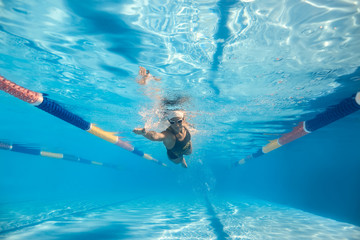 Fototapeta na wymiar Woman swims underwater