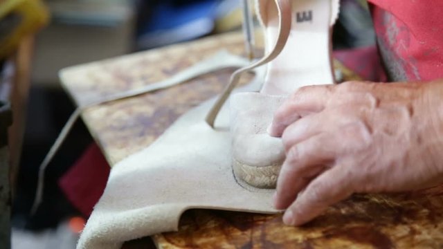 Calzolaio al Lavoro nella sua bottega artigianale. Disegno pianta del piede per suola. 