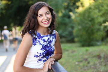 Fototapeta premium Attractive young smiling trendy dressed woman enjoying her time outside in park