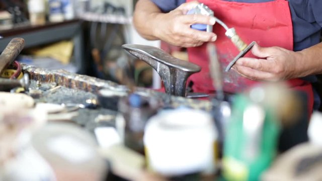 Calzolaio al Lavoro nella sua bottega artigianale. Incollatura suola scarpa donna. 