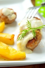 Meatballs with Bechamel sauce and fried potatoes. Close-up, selective focus