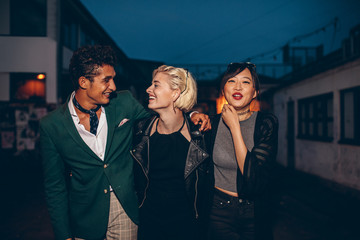 Friends walking on the street at night