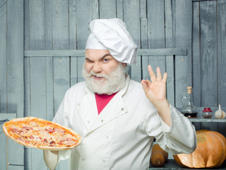 Bearded cook with pizza