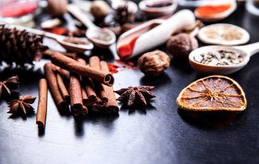 wooden spoons with spices on black background