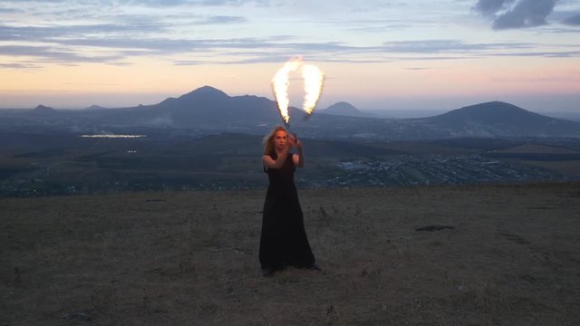 Woman twirling burning torch