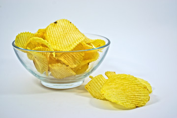 Crinkle cut potato chips in a bowl on a white background