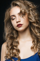Fototapeta premium Close portrait of a beautiful young girl with long hair. She loo